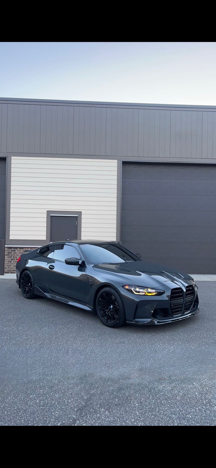 Black BMW M4 with professionally installed window tint, parked in a garage